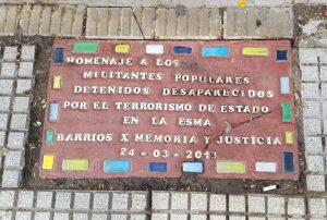 Placa en la calle que marca un lugar donde personas desaparecieron